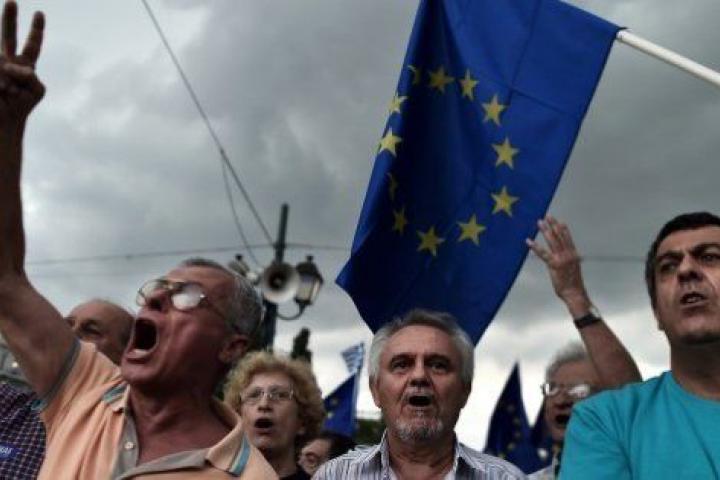 Pro-euro protesters hold European Union flags during a demonstration in front of the parliament in Athens on June 30, 2015. European leaders want to 'sink' Greece's ruling Syriza party to block the rise of other far-left, anti-austerity parties ...