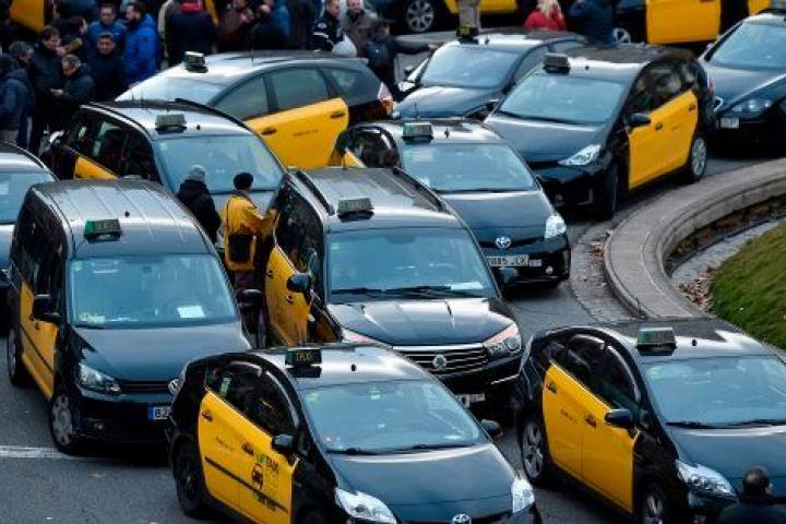Un grupo de taxistas bloquea una rotonda de la Gran Via de Barcelona.