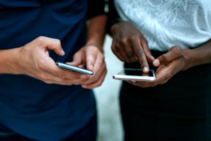 Dos personas utilizando el teléfono móvil.