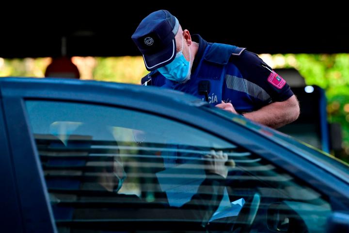 Un agente comprueba el documento que justifica la circulación de un vehículo en Madrid