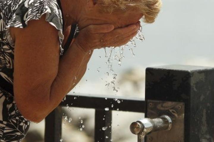 Una mujer se refresca en Marbella, Málaga, en una ola de calor de mayo de 2015.