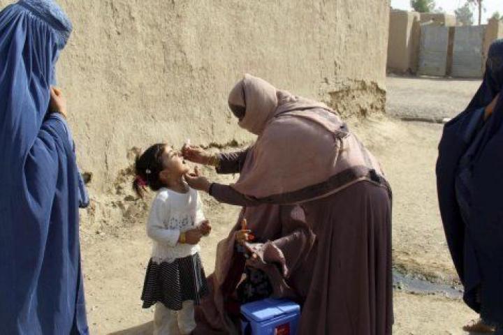 Trabajadoras sanitarias administran a una niña la vacuna contra la polio en Kandahar, Afganistán.