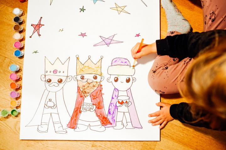 Una niña haciendo un dibujo de los Reyes Magos.