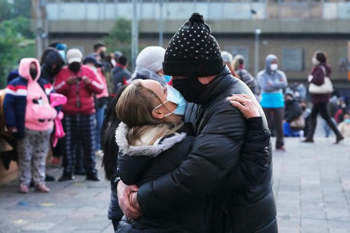 Una pareja se abraza con las mascarillas.