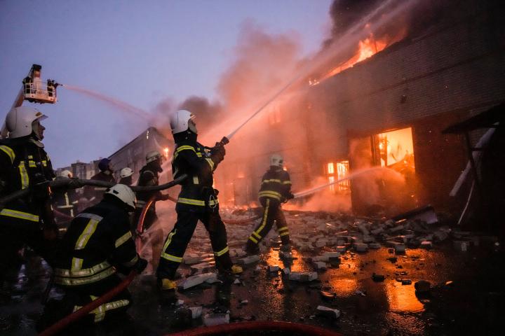 Un grupo de bomberos trata de apagar un fuego tras un bombardeo en Kiev, en la noche de ayer. 