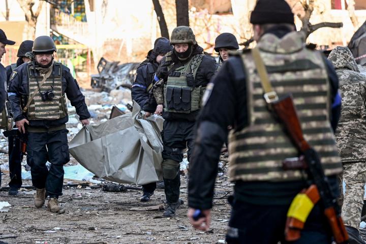 Elementos ucranianos llevan a una de las víctimas tras un ataque ruso a un edificio civil.