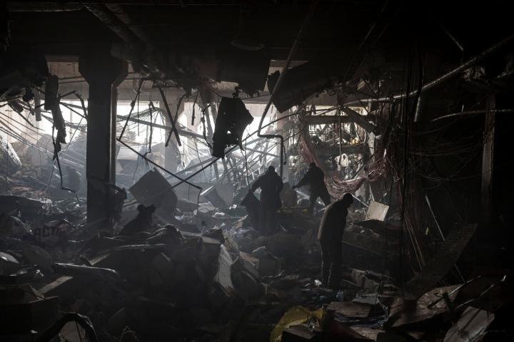 Soldados ucranianos y bomberos buscan supervivientes bajo las ruinas de un centro comercial bombardeado ene Kiev, el 21 de marzo. 