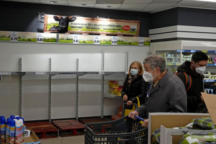 Unos clientes compran en un supermercado de Madrid con estanterías vacías por el paro de transportes, el pasado 23 de marzo.