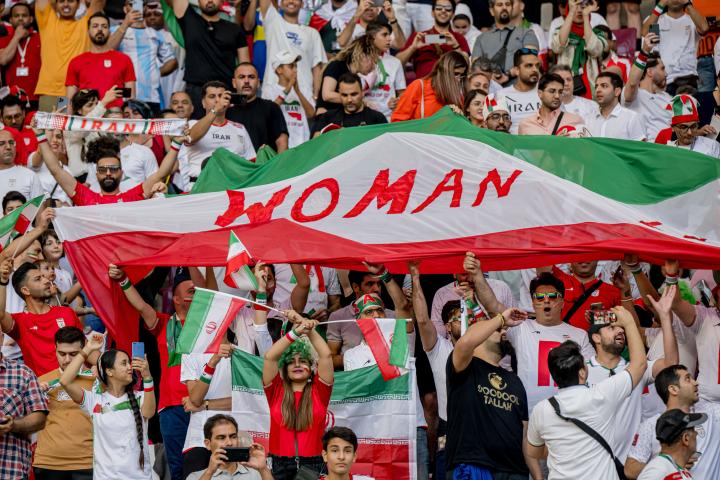 Aficionados iraníes sostienen carteles de "Woman Life Freedom" durante el partido del Mundial de Qatar 2022 contra Inglaterra.