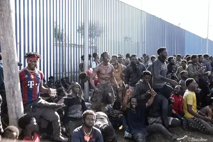 Un grupo de migrantes, alrededor de la valla que separa España y Marruecos.