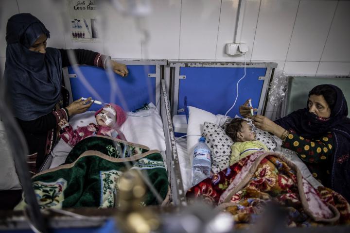 Dos mujeres atienden a sus hijos en un hospital de Afganistán.