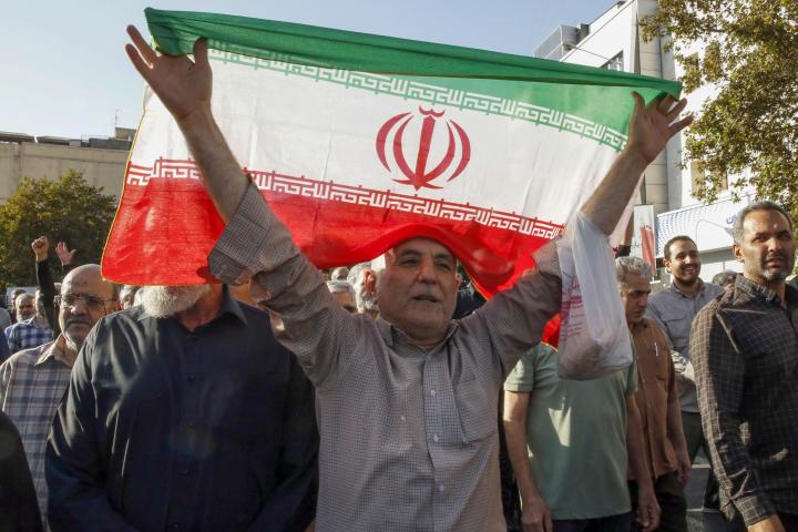 Foto de archivo de un hombre sosteniendo una bandera de Irán en una de las protestas por la muerte de Mahsa Amini.