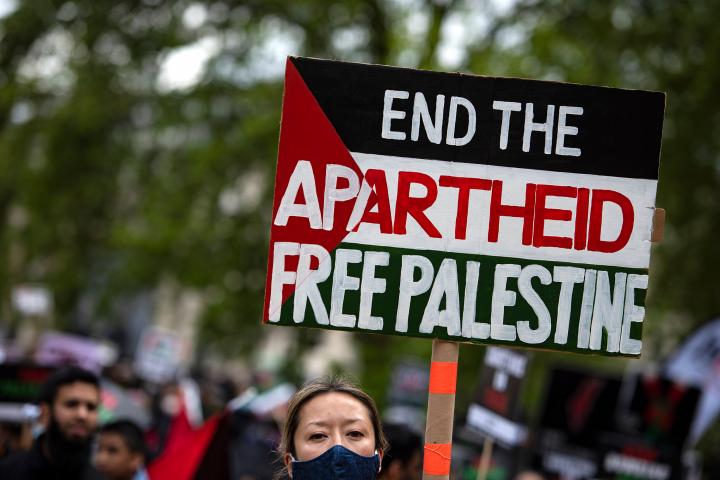 Una manifestante sostiene un cartel denunciando en "apartheid" de Israel y defendiendo la libertad de los palestinos en una marcha en Londres, el pasado 22 de abril. 