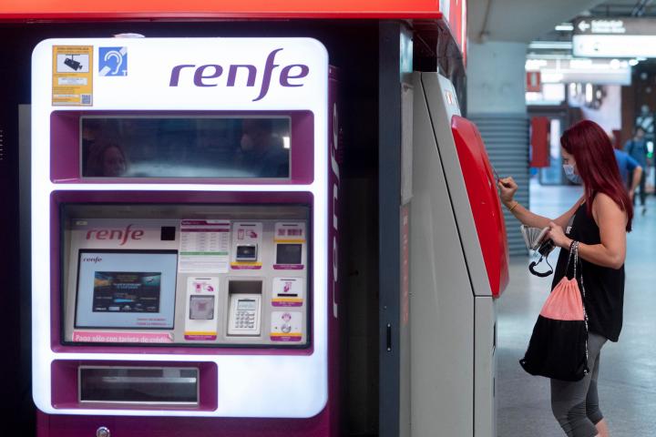 Una persona compra un billete en una taquilla de venta automática de Renfe