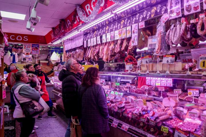 Clientes de un puesto del Mercado de Prosperidad, en Madrid, el día de Nochebuena de 2022.
