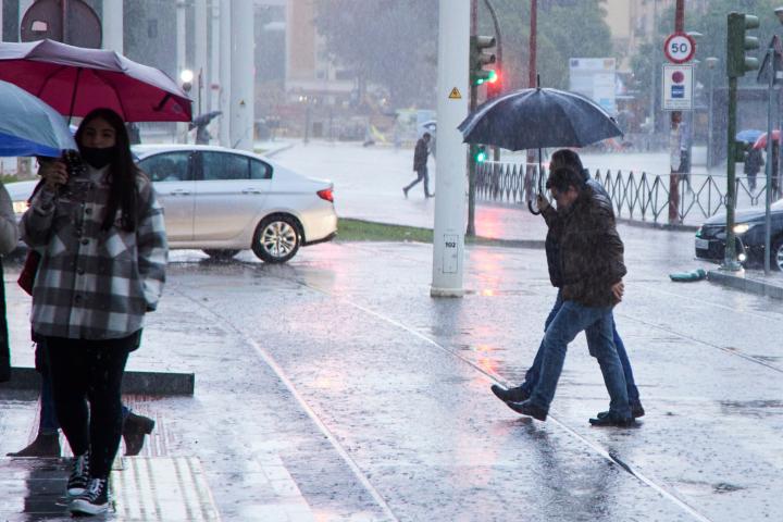 Personas paseando bajo la lluvia.
