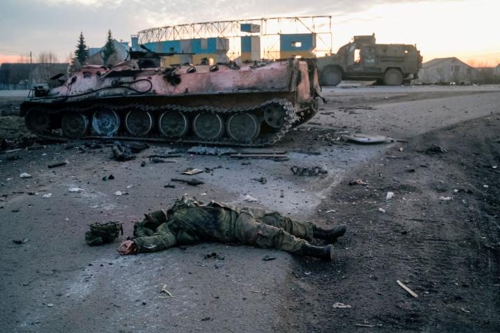 El cuerpo de un soldado sin insignias, posiblemente ruso, yace junto a un tanque destrozado en una carretera a las afueras de Jarkov, el primer día de la invasión rusa, 24 de febrero de 2022. 