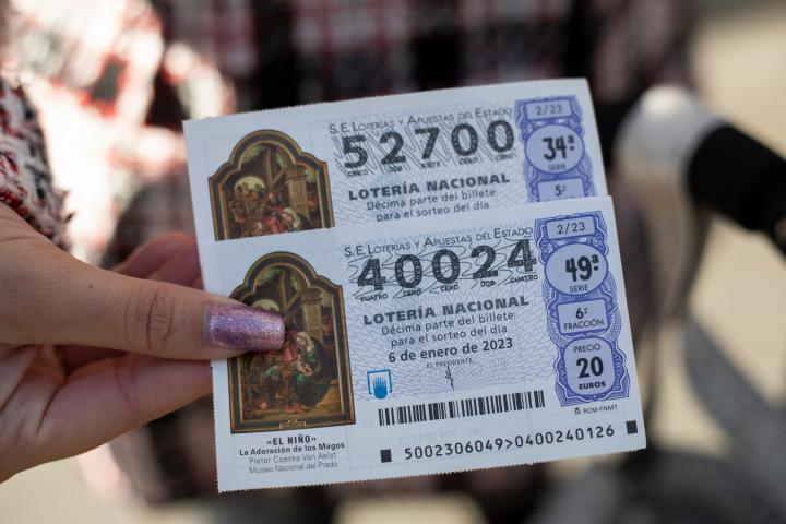 Una persona sostiene dos décimos para el Sorteo Extraordinario de Lotería del Niño