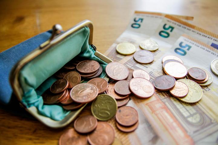 Foto de archivo de un monedero con monedas y billetes.