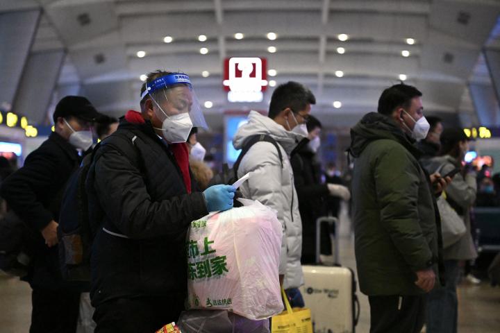Pasajeros con protección frente al covid, en una estación de tren de Pekín (China), el 5 de enero de 2023. 