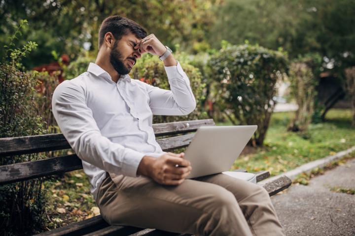 Un hombre, agobiado frente a un ordenador en un parque, una escena cada vez menos extraña