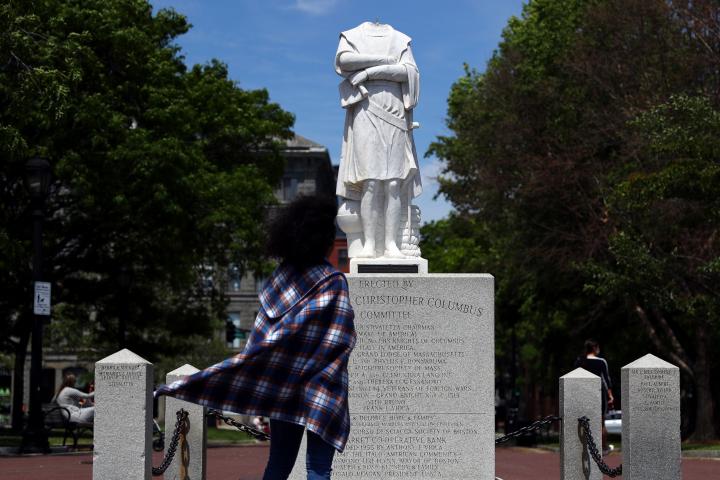 BOSTON, MASSACHUSETTS - JUNE 10: A woman looks at a statue depicting Christopher Columbus with its head removed at Christopher Columbus Waterfront Park on June 10, 2020 in Boston, Massachusetts. The statue was beheaded overnight and is scheduled...