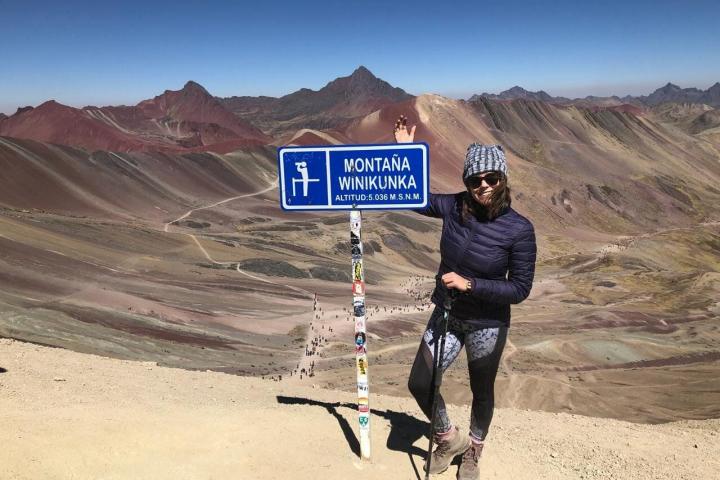 La autora en la cima de la montaña de colores en Perú.