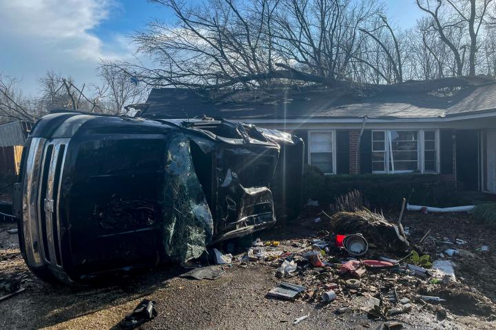 Un vehículo dañado yace frente a una residencia en Selma, Alabama. 