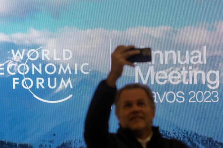 Un hombre se toma un selfie ante el logo del Foro de Davos, ayer, en la ciudad suiza. 