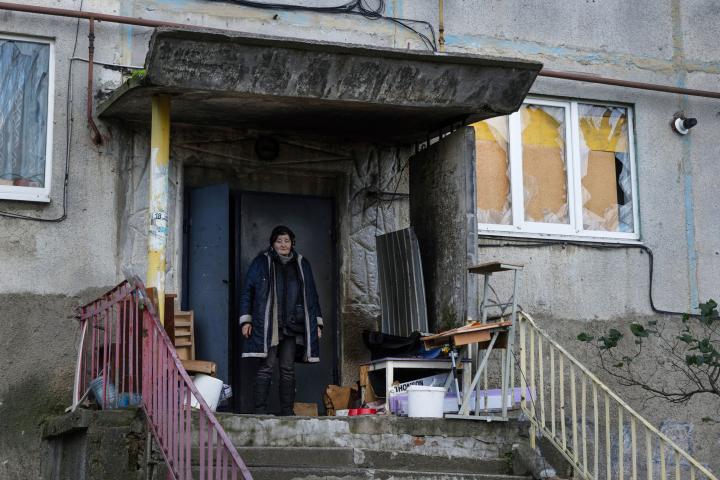 SOLEDAR,UKRAINE - NOVEMBER 13:   A resident who has remained in the city is in front of the entrance to her building with windows destroyed by the explosions on November 13,2022 in Soledar, Ukraine. The last inhabitants who remained there only l...