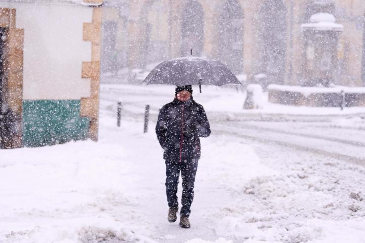 Una persona camina por una calle cubierta de nieve