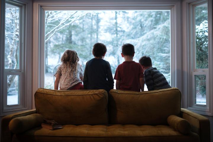 Imagen de archivo de varios niños en un salón con calefacción, en pleno invierno.
