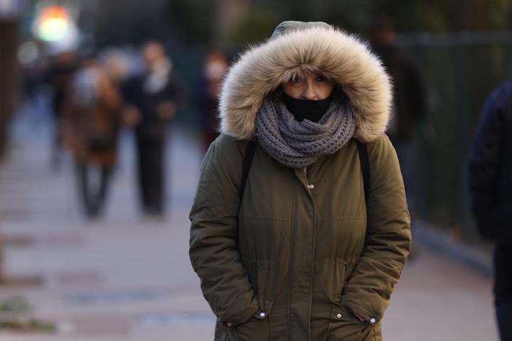 Una mujer pasea por Madrid cuando la capital se encuentra en aviso amarillo por temperaturas mínimas.
