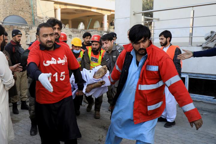 Personal de emergencias transporta el cuerpo de una de las personas muertas en el ataque a la mezquita, ayer, en Peshawar.