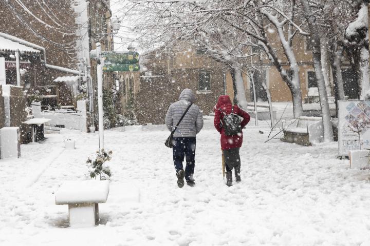 Dos personas caminan por una calle cubierta de nieve en Mallorca.