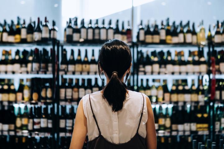 Imagen de archivo de una mujer eligiendo vinos.