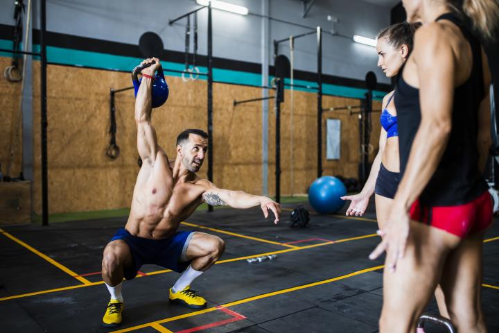 Un hombre levanta una pesa en una clase de crossfit