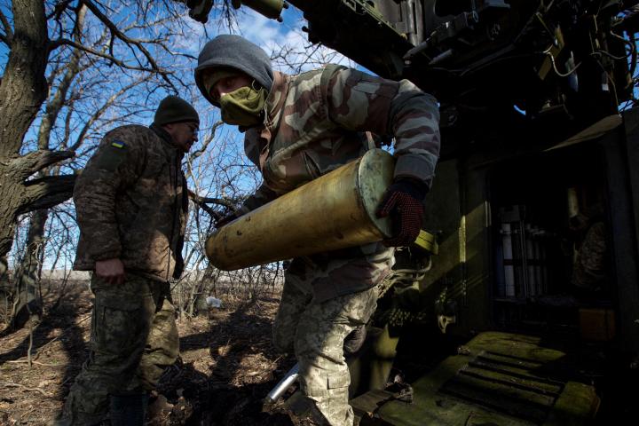 Dos soldados ucranianos cargando una batería de artillería 2S5 Giatsint-S, en el frente de Bajmut (Donetsk).