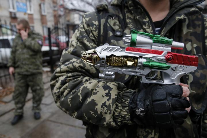 Un rebelde pro-Rusia sostiene un arma de juguete en las calles de Donetsk.