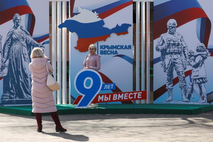 Una mujer se fotografía ante una instalación que conmemora los nueve años de Crimea en manos de Rusia. Los lemas dicen: "Primavera de Crimea. Hemos estado juntos durante 9 años".