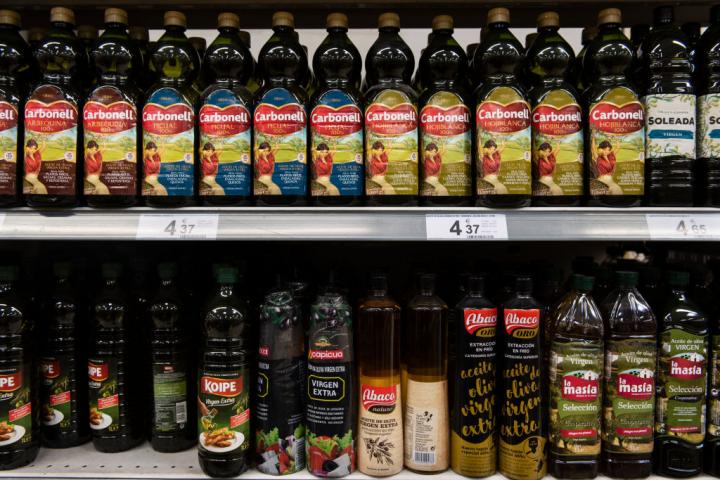 Varias botellas de aceite de oliva, en el estante de un supermercado.