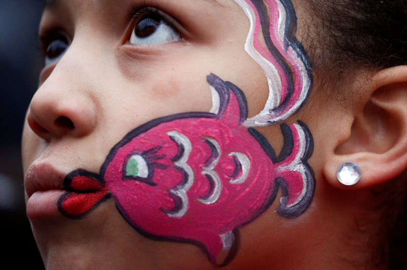 Una niña luce una sardina pintada en la cara, en la manifestación de ayer en Bolonia. 