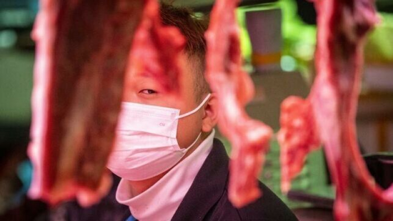 Un carnicero se protege con una mascarilla en un mercado de la ciudad de Guangzhou, en China.