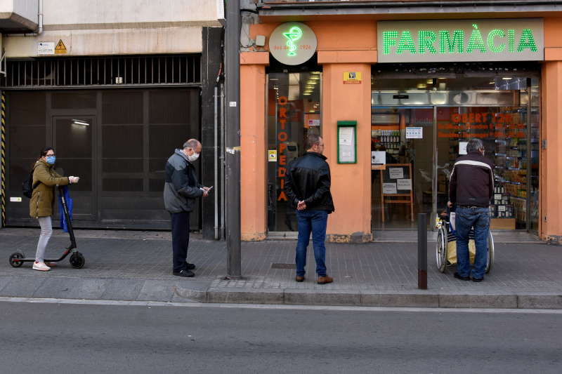 Varios ciudadanos hacen cola para la farmacia en Hospitalet (Barcelona).