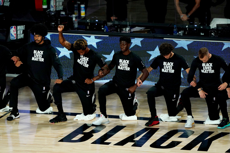Jugadores de los Brooklyn Nets, rodilla en tierra, en honor del movimiento Black Lives Matter.