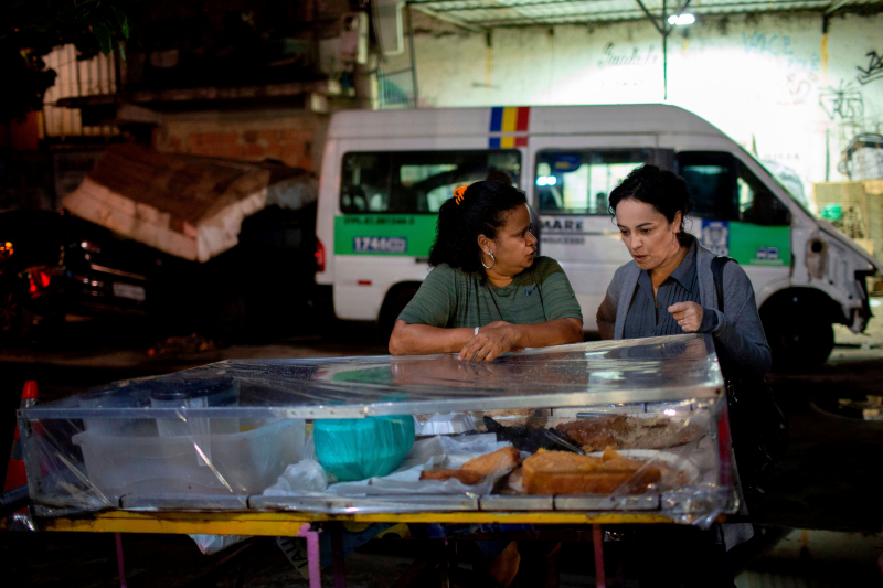 Tiburi charla con una vendedora ambulante en la favela de Mare, en Río de Janeiro (Brasil), en septiembre de 2018, poco antes de exiliarse a París (Francia).
