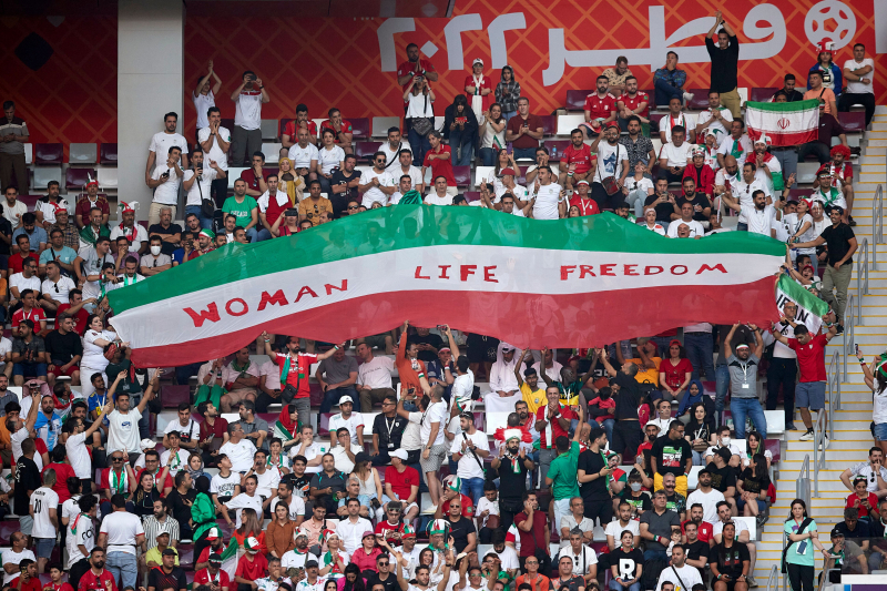 Aficionados iraníes sostienen carteles de "Woman Life Freedom" durante el partido del Mundial de Qatar 2022 contra Inglaterra. 
