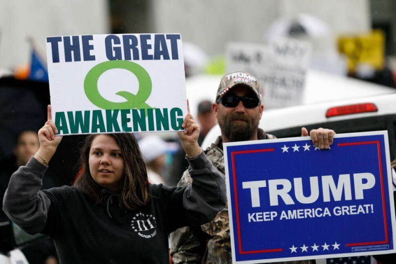 Teóricos de la conspiración de QAnon sostienen unas pancartas en apoyo a Trump en Oregón el 2 de mayo de 2020.