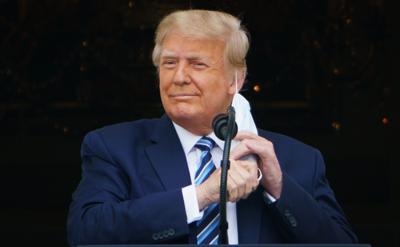 US President Donald Trump taking his mask off before speaking at a rally from the South Portico of the White House in Washington, DC on October 10, 2020 shows. - Trump spoke publicly for the first time since testing positive for Covid-19, as he ...