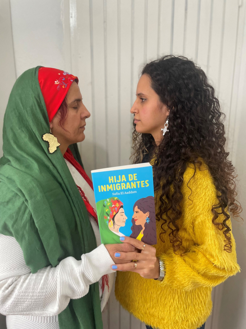 Safia El Addaam (d) y su madre (i) reproducen la imagen de la portada de 'Hija de inmigrantes' (Nube de Tinta).